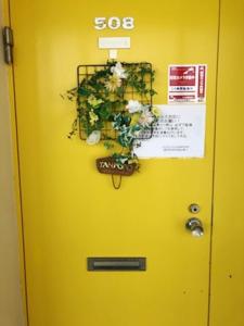 a yellow door with a potted plant on it at Fuji Subashiri Condominium Tannpopo in Oyama