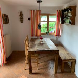 a wooden table and chairs in a room with a window at Apartment with a stunning view of the alps - Wohnung mit atemberaubenden Blick auf die Alpen in Fischbachau
