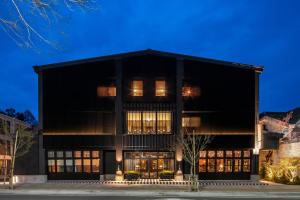 ein Gebäude mit schwarzer Fassade in der Nacht in der Unterkunft Twin-Line Hotel Karuizawa Japan in Karuizawa