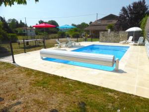 a swimming pool in a yard with two lawn chairs at Gite les Fleurs in Eymet