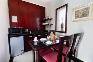 a small kitchen with a table and a microwave at Golden Ocean Marina Hotel in El Alamein