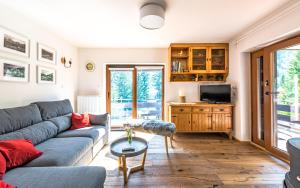 ein Wohnzimmer mit einem Sofa und einem TV in der Unterkunft House Moose't Getaway, Kranjska Gora in Kranjska Gora