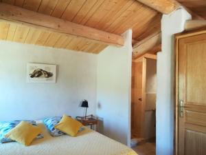 una camera con letto e soffitto in legno di La Ferme Constantin a Fayence