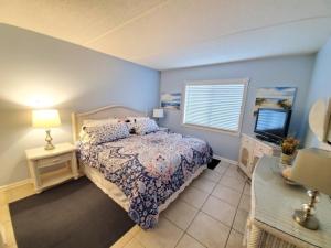 a bedroom with a bed and a lamp and a window at St, Augustine Ocean And Racquet 2204 Condo in Saint Augustine