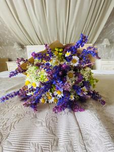 um ramo de flores sentado numa cama em Barackvirág Apartmanház em Tihany
