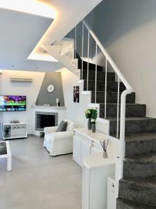 a living room with white furniture and a staircase at Casa Stellina in Perea