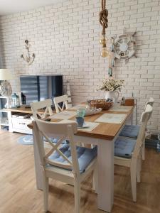 a dining room with a wooden table and chairs at Apartament Bursztyn in Pobierowo