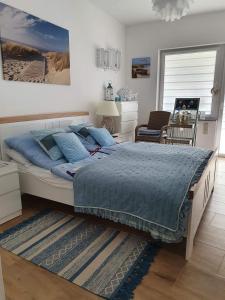 um quarto com uma cama grande e um edredão azul em Apartament Bursztyn em Pobierowo