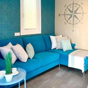 ein blaues Sofa mit Kissen und einem Tisch in einem Zimmer in der Unterkunft Bonita HouseBoat Apartment Portorose in Portorož