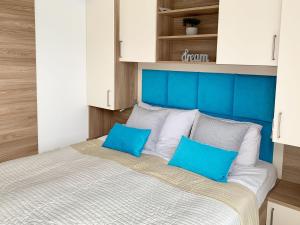 Schlafzimmer mit einem Bett mit blauem Kopfteil und weißen Schränken in der Unterkunft Bonita HouseBoat Apartment Portorose in Portorož