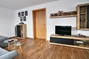 a living room with a couch and a flat screen tv at Albglück in Gammertingen