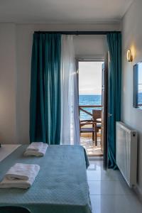 1 dormitorio con cama y vistas al océano en AR apartment, en Platanidia