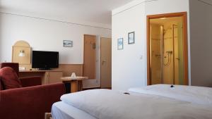 艾夏的住宿－Hotel Gasthof Specht，酒店客房设有两张床、一把椅子和电视。