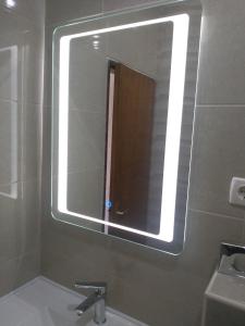 uma casa de banho com um espelho grande e um lavatório em Apartments Barbara em Pinezici
