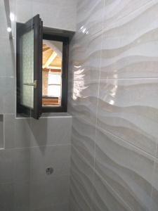 a bathroom with a shower with a window and a wall at Apartments Barbara in Pinezici