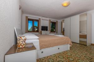 a large bedroom with a bed and a television at Apartmani Pilaš in Dramalj