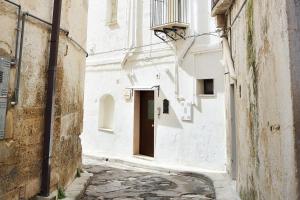alejka z drzwiami w białym budynku w obiekcie La Gravina w mieście Gravina in Puglia
