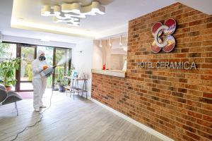 un hombre está pintando una pared de ladrillo en una habitación en Hotel Ceramica en Iaşi