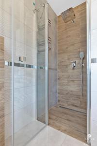 W łazience znajduje się prysznic ze szklanymi drzwiami. w obiekcie Jantar Apartamenty - Casa Francesco w Grzybowie