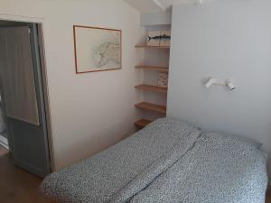 sypialnia z łóżkiem i półką na książki w obiekcie Vakantiehuis La petite Redousse w mieście Renesse