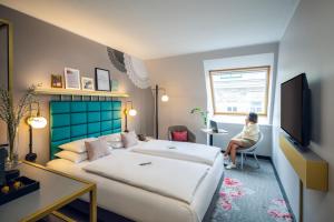 a woman sitting in a chair in a hotel room at Mercure Wien Zentrum in Vienna