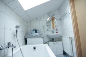 Un baño blanco con lavabo y espejo. en Strandnahe Ferienwohnungen mit Garten, en Ostseebad Koserow 39 fotos más