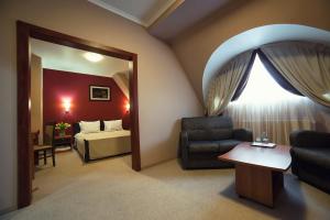 un soggiorno con divano, letto e specchio di Hotel Praha a Užhorod