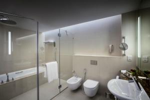 
a white toilet sitting next to a white sink at Bab Al Qasr Hotel in Abu Dhabi
