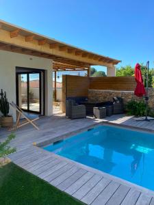 a swimming pool in a yard with a patio at le pool house in Nîmes