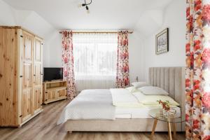 Un dormitorio con una cama grande y un televisor. en Karina, en Wisła 28 fotos más