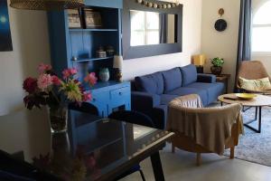 a living room with a blue couch and a table at apartamento Costa Sancti-Petri La Barrosa Chiclana in Chiclana de la Frontera