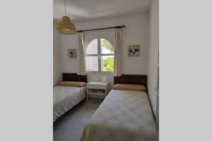 sypialnia z dwoma łóżkami i oknem w obiekcie apartamento Costa Sancti-Petri La Barrosa Chiclana w mieście Chiclana de la Frontera