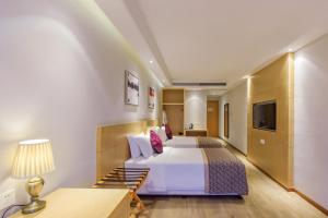 um quarto de hotel com uma cama e uma televisão em Novo Hotel Chongqing em Chongqing