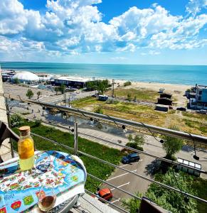 a table on a balcony with a view of a beach at Scoica Alba Mamaia Nord Summerland in Mamaia