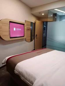 um quarto com uma cama e uma televisão de ecrã plano em Thank Inn Chain Hotel Weifang High-tech Zone Weifang East Expressway Intersection em Weifang