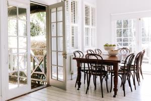 a dining room with a wooden table and chairs at French Cottage Beechworth with stunning Alfresco Garden in Beechworth
