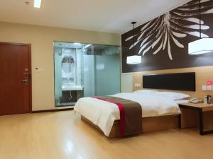 a bedroom with a large bed and a glass door at Thank Inn Chain Hotel Hubei Yidu Chengxiang in Yidu