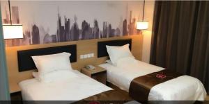 a hotel room with two beds with white sheets at Thank Inn Chain Hotel Taizhou Dainan Guzhuang Village Bus Station in Taizhou