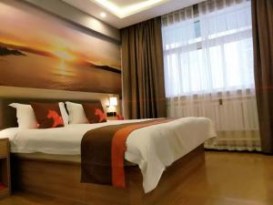 a bedroom with a large bed with a large window at JUN Hotels Shandong Zaohuang Tengzhou Jinghe West Road in Tengzhou