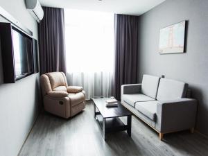 a living room with a couch and a chair and a table at Thank Inn Chain Hotel Zhejiang Huzhou Deqing County Xinshi Town Huancheng West Road in Huzhou