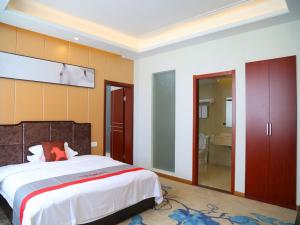 a bedroom with a large bed and a bathroom at JUN Hotels Anhui Xuancheng Xuanzhou District Industrial Park in Xuancheng