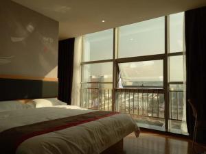 a bedroom with a bed and a large window at Thank Inn Chain Hotel Chizhou Zhanqian District Railway Station in Chizhou