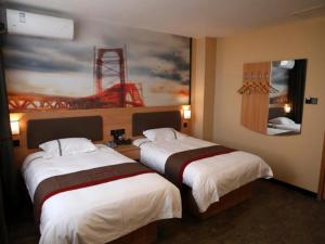 two beds in a hotel room with a painting on the wall at Thank Inn Chain Hotel Shandong Linyi Lanshan District Liguan Town in Linyi