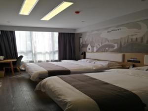 a hotel room with three beds and a window at Thank Inn Chain Hotel Yangzhou Hanjiang District Chahe University Town in Yangzhou