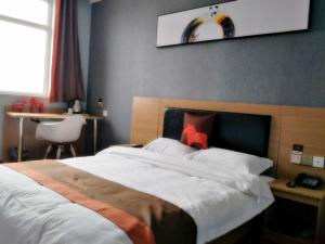 Un dormitorio con una cama grande con un osito de peluche rojo. en JUN Hotels Hebei Handan Weixian Bus Station Store, en Handan