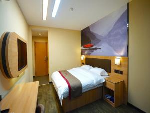 Cette chambre comprend un lit et une télévision. dans l'établissement Thank Inn Plus Hotel Handan Wei County Xianbiao, à Handan