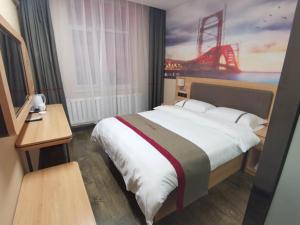 a bedroom with a large bed with a painting on the wall at Thank Inn Chain Hotel Hohhot Xincheng District Xinhua Plaza in Hohhot