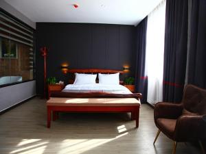 a bedroom with a bed and a couch and a chair at JUN Hotels Hebei Hengshui Gucheng County Yingrui Plaza in Hengshui +7 photos