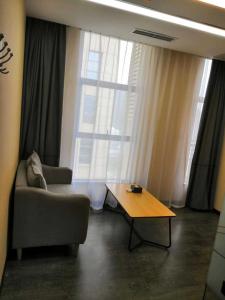 uma sala de estar com um sofá e uma mesa de centro em Thank Inn Plus Hotel Guizhou Qiannan Duyun Wanda Plaza Store 