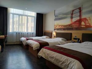 um quarto de hotel com três camas e um quadro na parede em Thank Inn Chain Hotel Weifang High-tech Zone Weifang East Expressway Intersection em Weifang